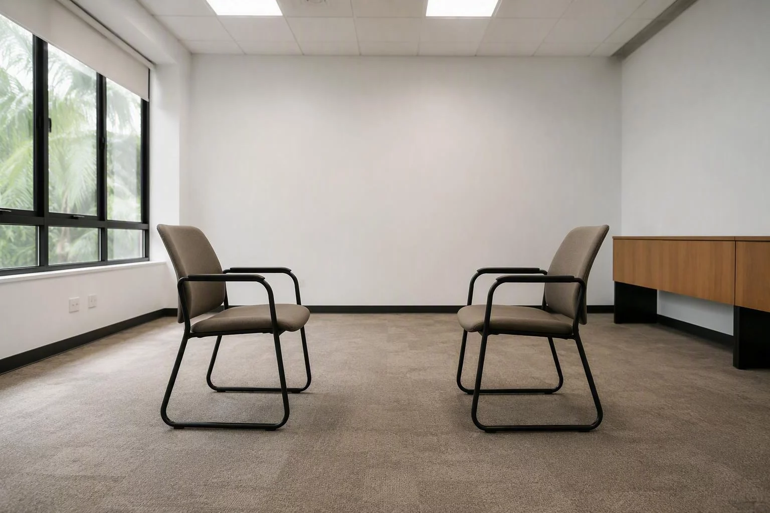 Duas cadeiras iguais frente a frente em uma sala de reunião vazia